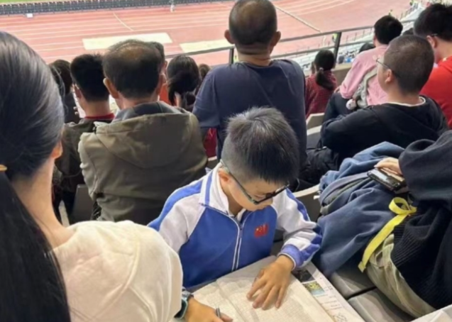 国足赛前，多名小学生被发现在看台写作业